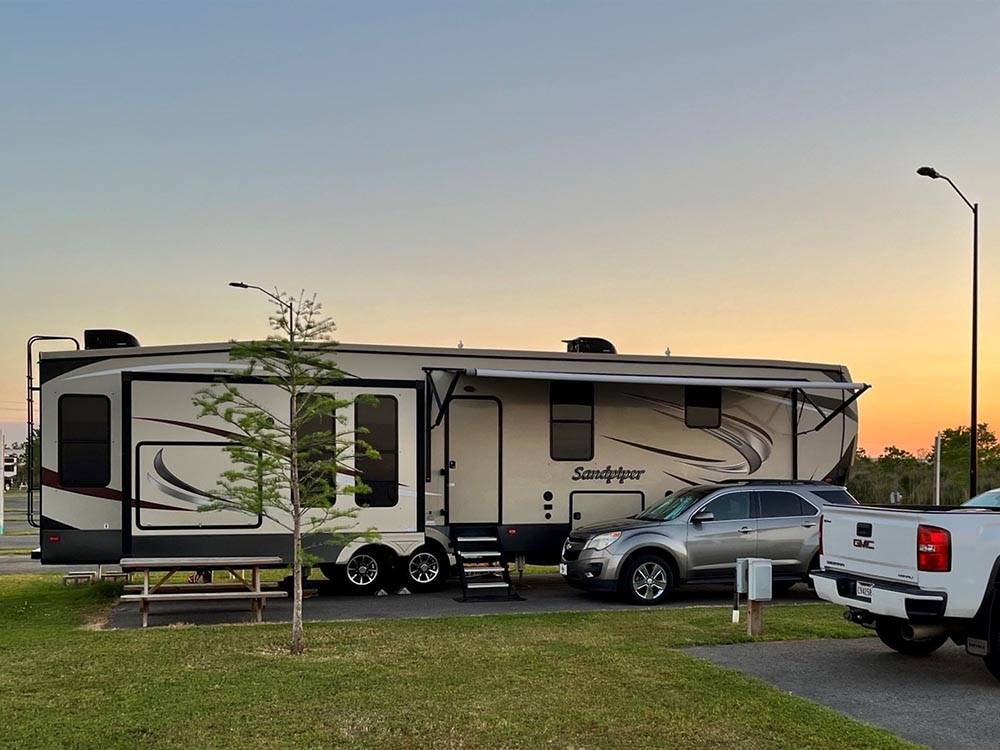 A fifth wheel trailer backed in at LAKE CHARLES RV RESORT BY RJOURNEY