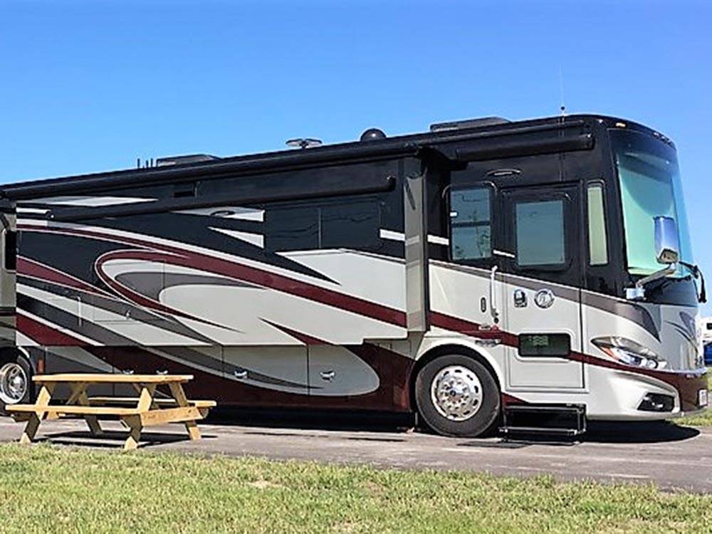 Class A motorhome in a gravel site at LAKE CHARLES RV RESORT BY RJOURNEY