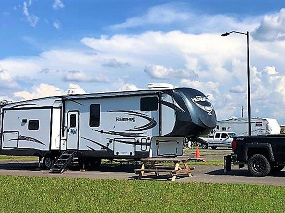 Fifth wheel trailer in a gravel site at LAKE CHARLES RV RESORT BY RJOURNEY