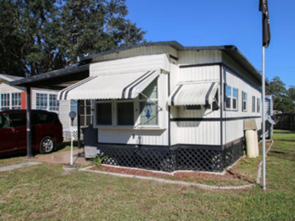 Sunny mobile home with flag outsideat The Oaks at Zephyrhills