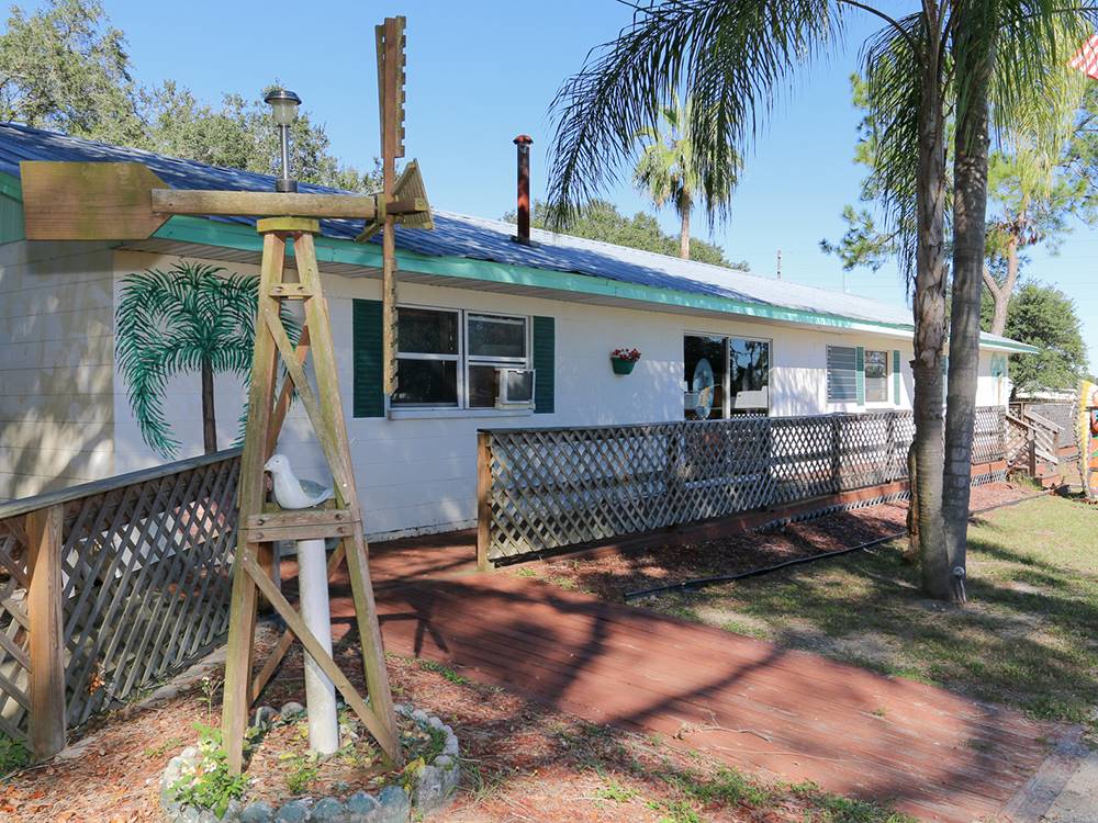 View of the clubhouse with windmill and palm trees at The Oaks at Zephyrhills