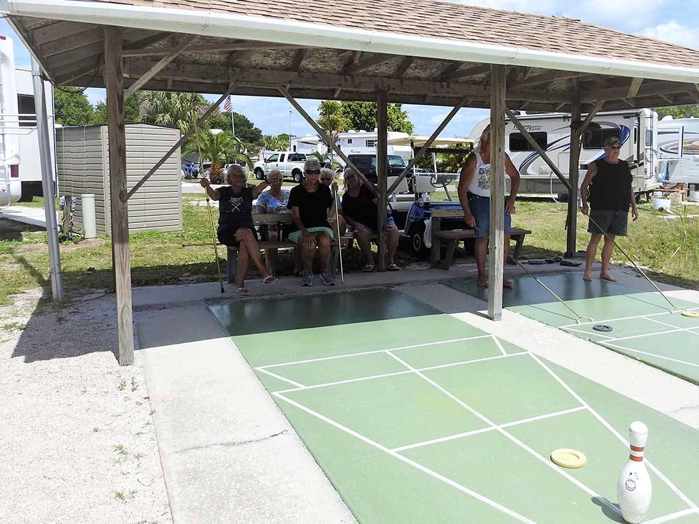 A group of people playing shuffleboard at GRANDMA'S GROVE RV PARK