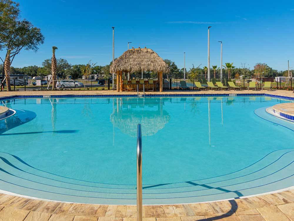 Pool with covered gazebo in background at SUNKISSED VILLAGE RV RESORT