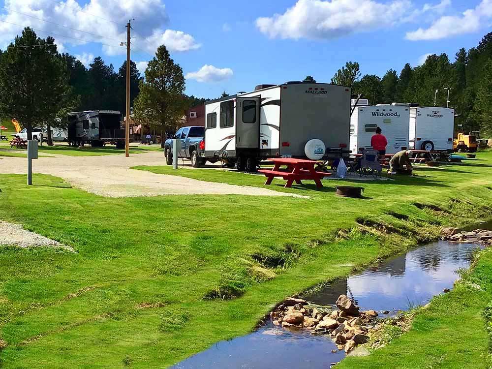 A row of trailers parked by the water at CUSTER CROSSING FAMILY CAMPGROUND