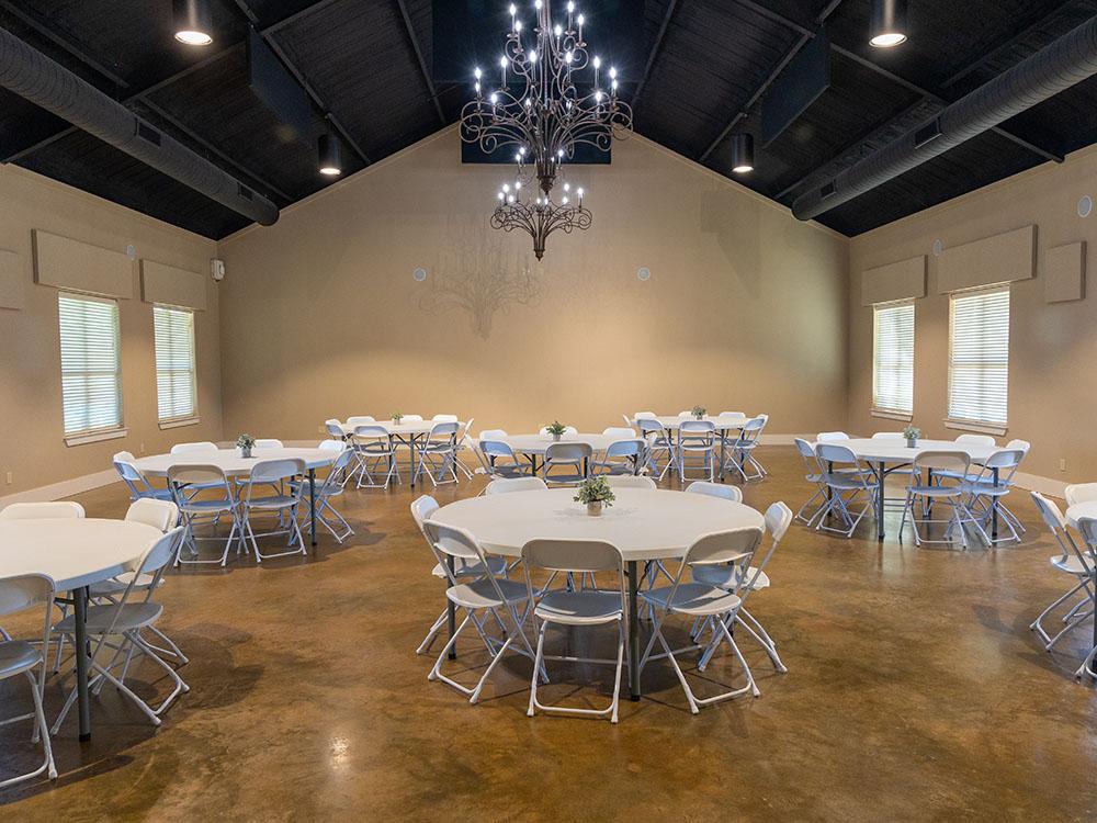 Interior of the rec hall with tables and chairs at TEXAS RANCH RV RESORT