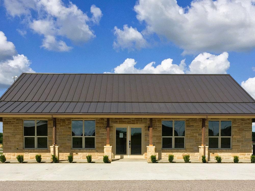 Exterior of the gold brick rec hall at TEXAS RANCH RV RESORT