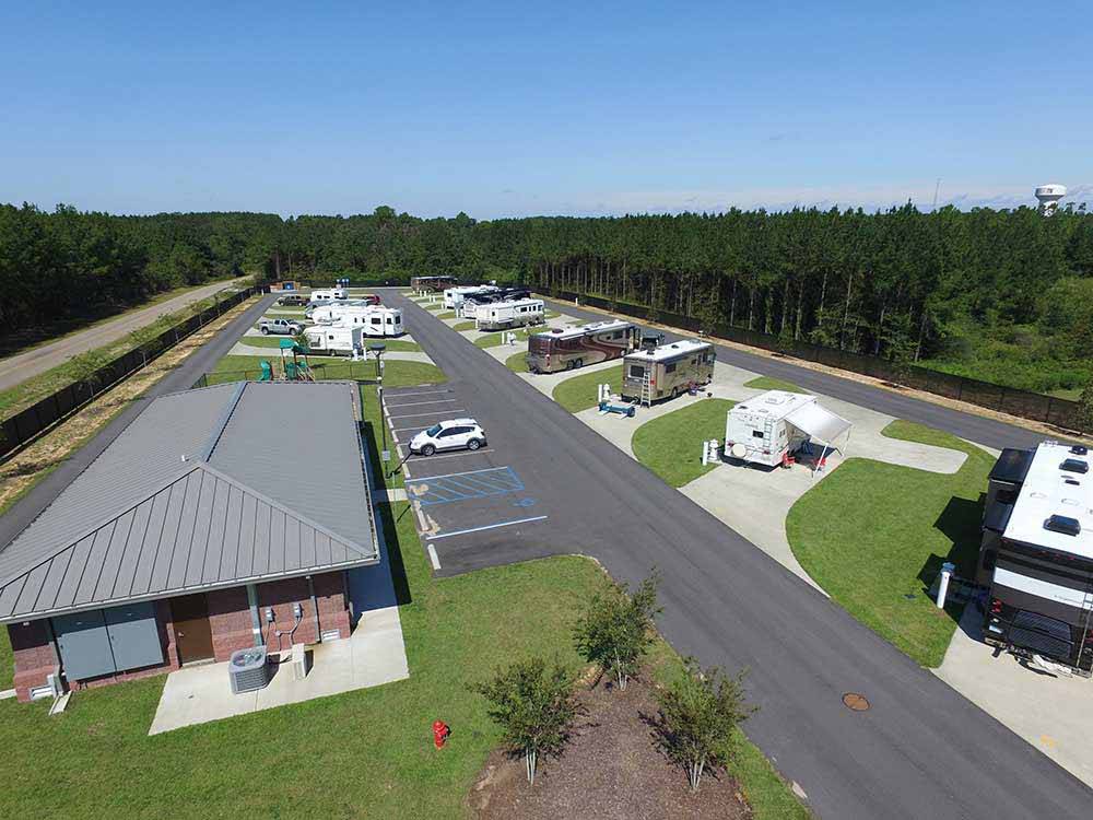 Building and RVs parked in middle of green trees at WIND CREEK ATMORE CASINO RV PARK