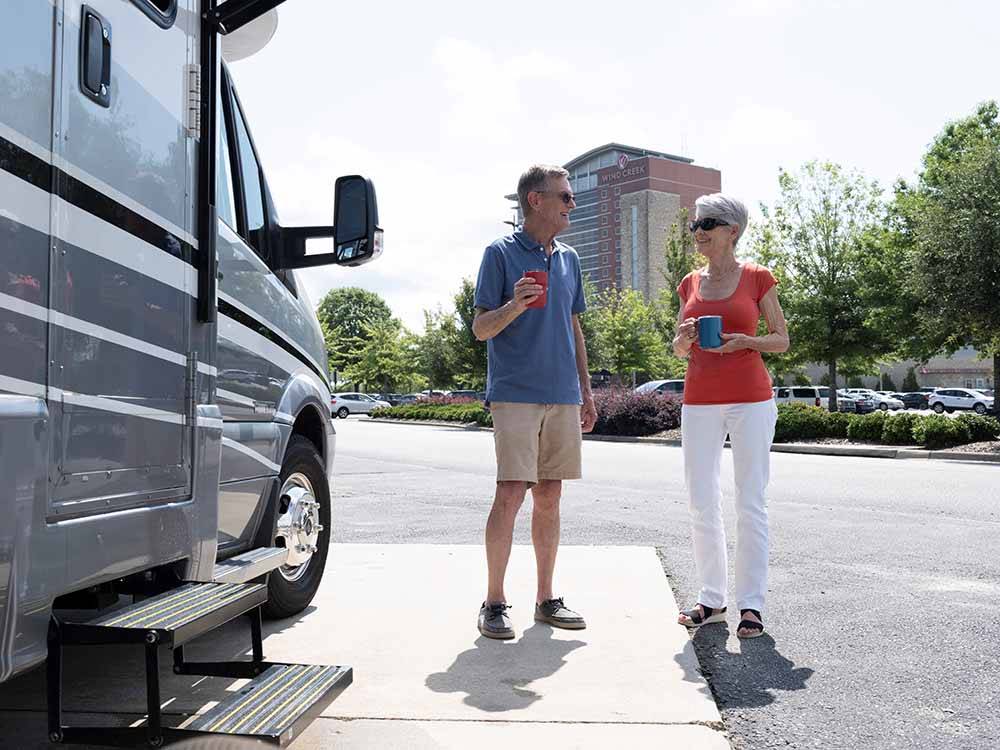 A couple standing by their Class B trailer at WIND CREEK ATMORE CASINO RV PARK