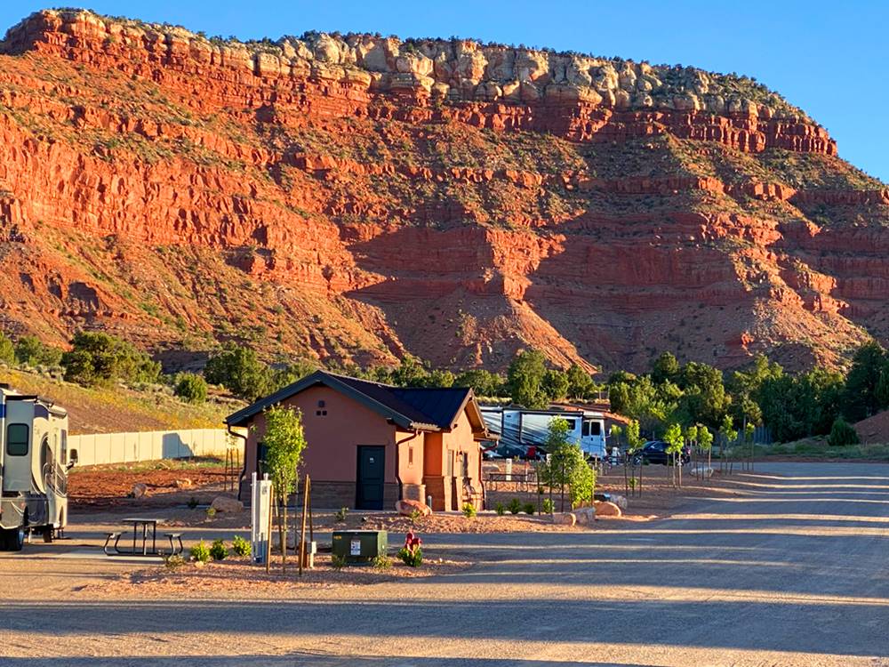 Restroom building next to sites and beautiful view of the mountain at GRAND PLATEAU RV RESORT AT KANAB