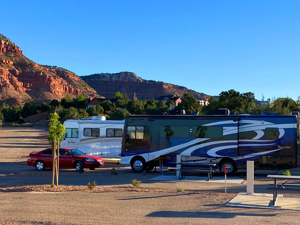 Two motorhomes parked in back in sites at GRAND PLATEAU RV RESORT AT KANAB