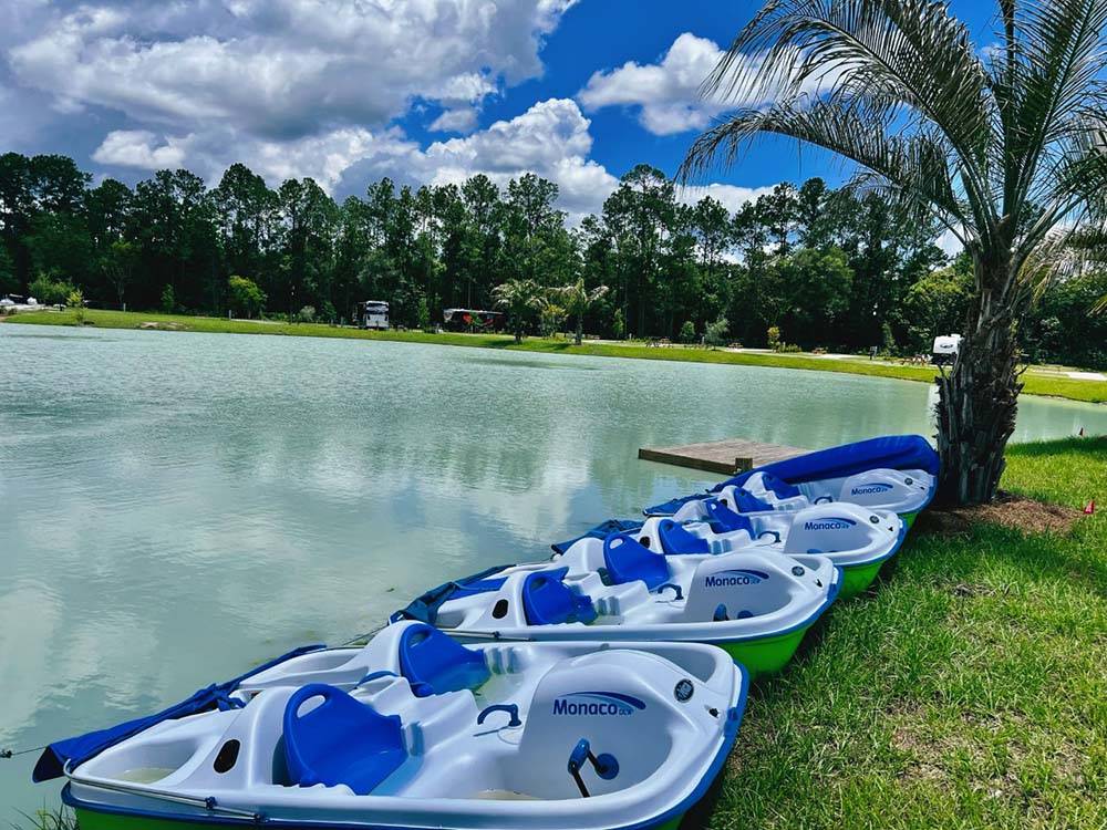 A row of paddle boats on the lake at ISLAND OAKS RV RESORT