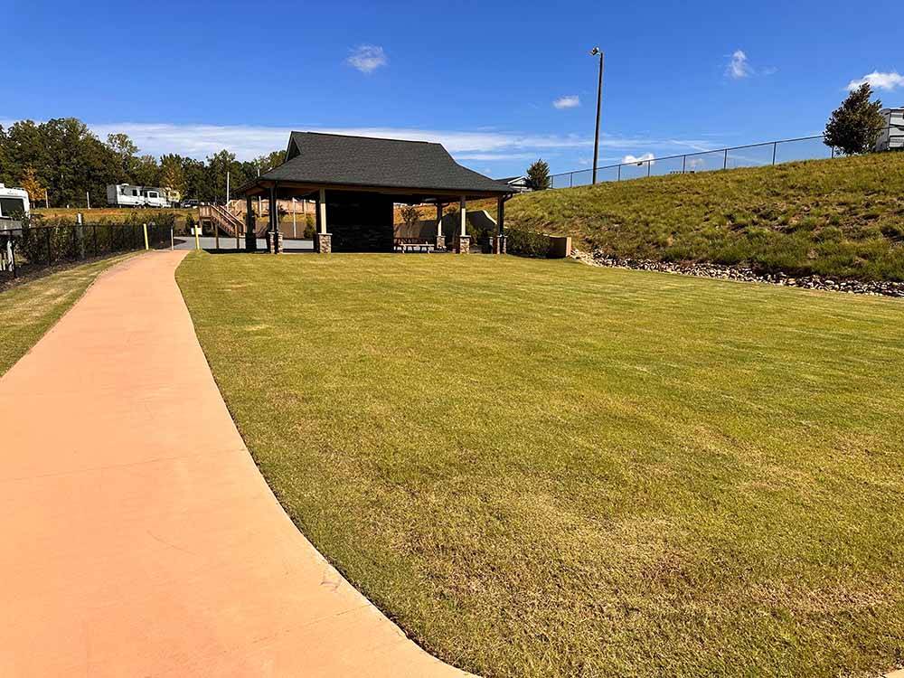 A walking path leading to a covered picnic area at CLEMSON RV PARK AT THE GROVE