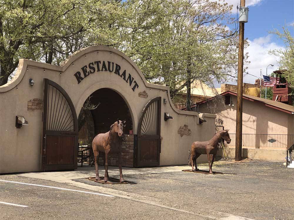 The front entrance of a restaurant with horse statues nearby at J & J RV PARK