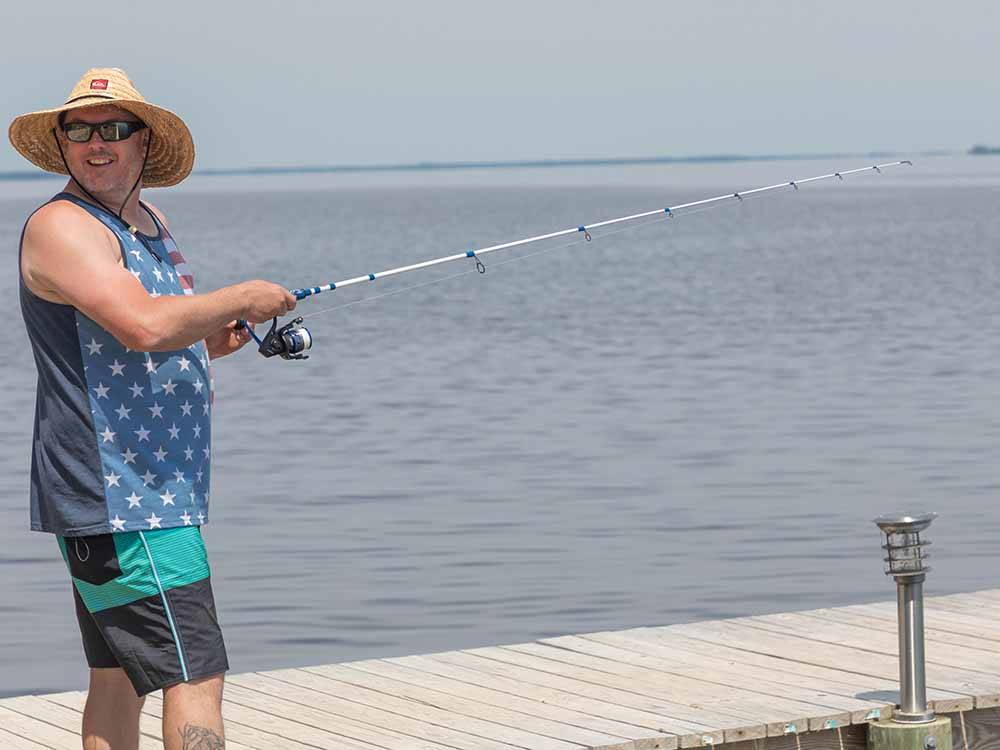A man fishing off of the pier at OUTER BANKS WEST/CURRITUCK SOUND KOA HOLIDAY