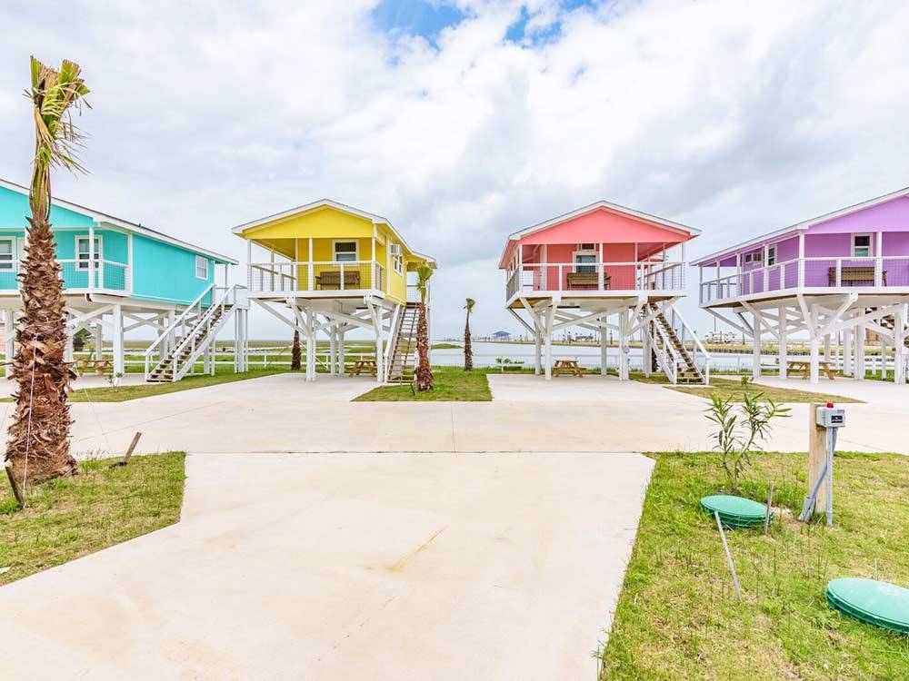 A row of colorful rental cabins at BLUE WATER RV RESORT