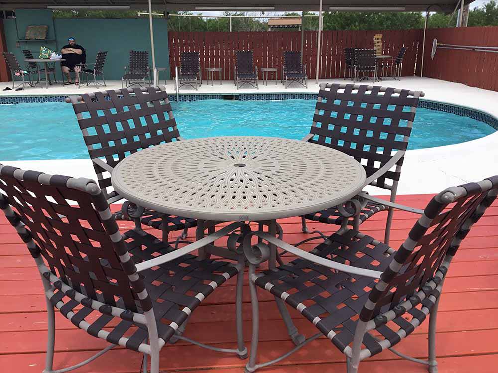 Table and chairs at the pool at Cotulla Camp Resort