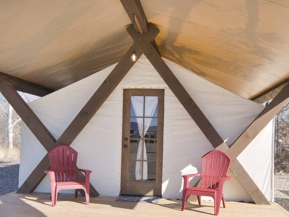 Two red chairs in front of a glamping tent at VERDE RANCH RV RESORT