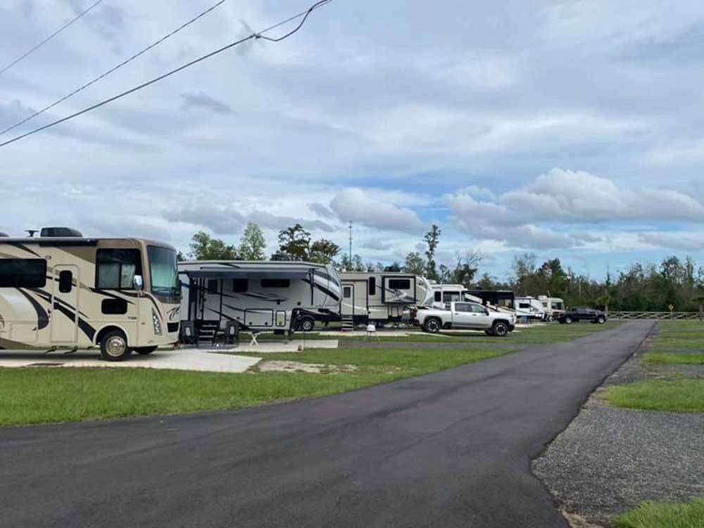 Motorhomes and fifth wheels backed in on the paved RV sites at STAY N GO RV