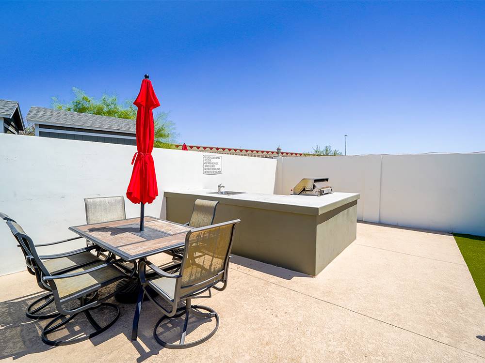 Table and chairs with sun umbrella at Deer Valley RV Park