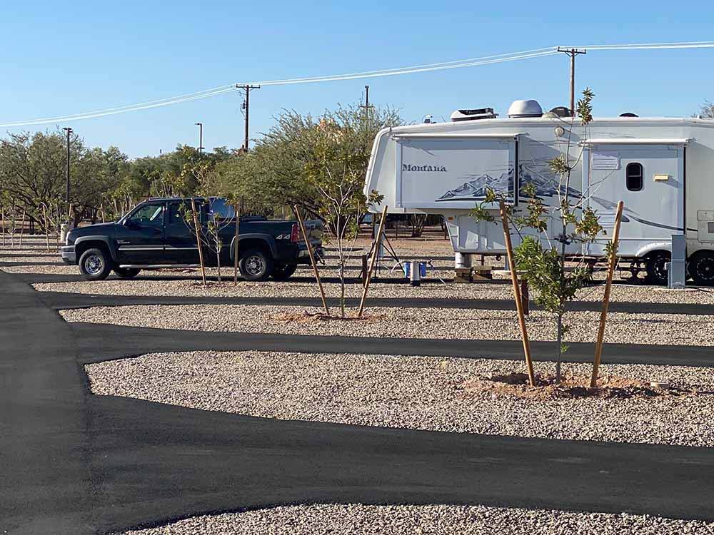 Black truck parked in front of a fifth wheel in a back in site at CASINO DEL SOL RV PARK