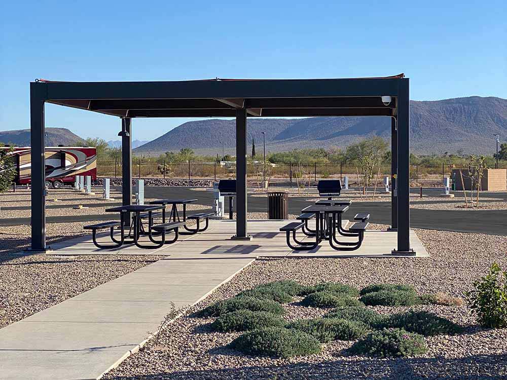 Picnic benches and barbecue pits under a pavilion at Casino Del Sol RV Park