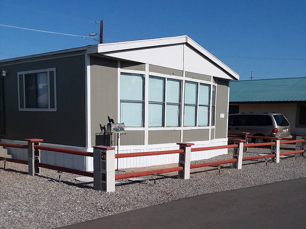 Manufactured home surrounded by wooden fence at GOLDWATER MOBILE HOME & RV PARK