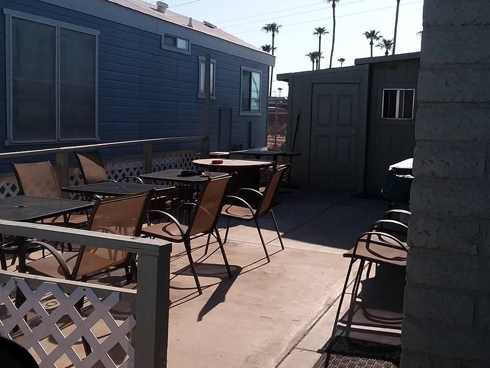 Chairs and tables next to manufactured home at GOLDWATER MOBILE HOME & RV PARK