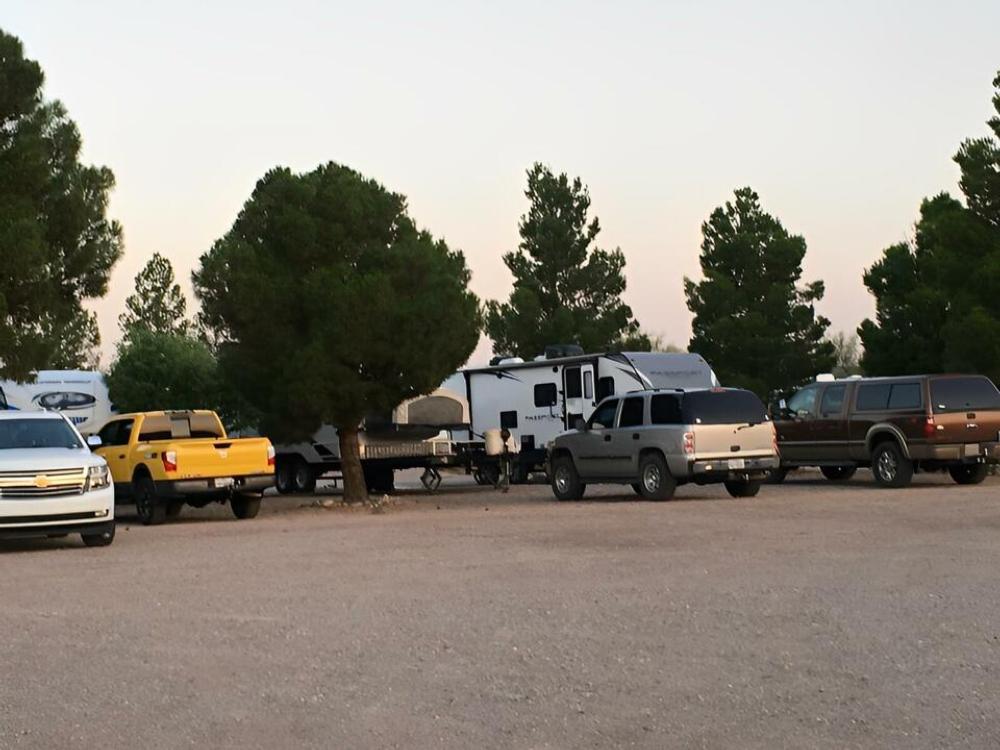 Travel trailers and vehicles parked at gravel sites at Caballo Country Store & RV Park