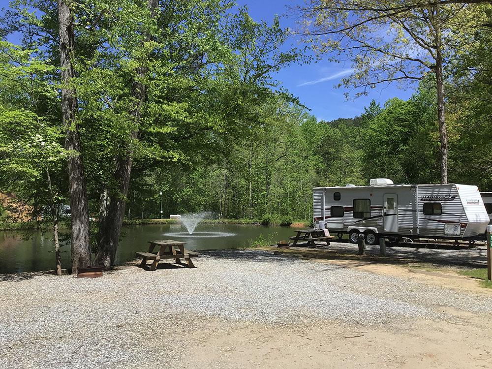 A travel trailer parked with a lake view at JENNY'S CREEK FAMILY CAMPGROUND