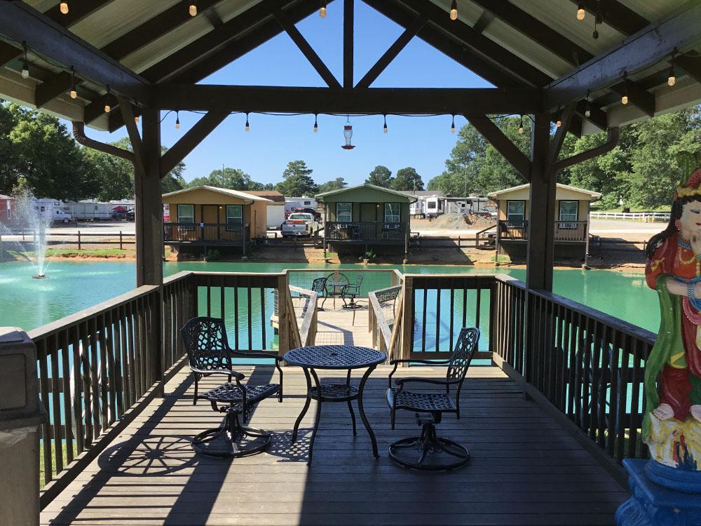 Seating under a covered deck overlooking the pond at TEXARKANA RV PARK