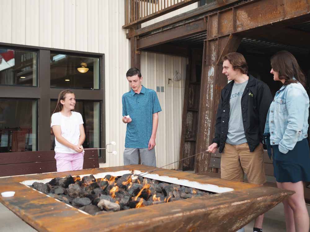 People standing around a modern fire pit at IRON SPRINGS ADVENTURE RESORT