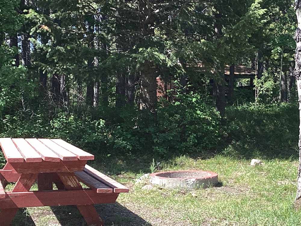 A red picnic bench and fire ring at RED EAGLE CAMPGROUND