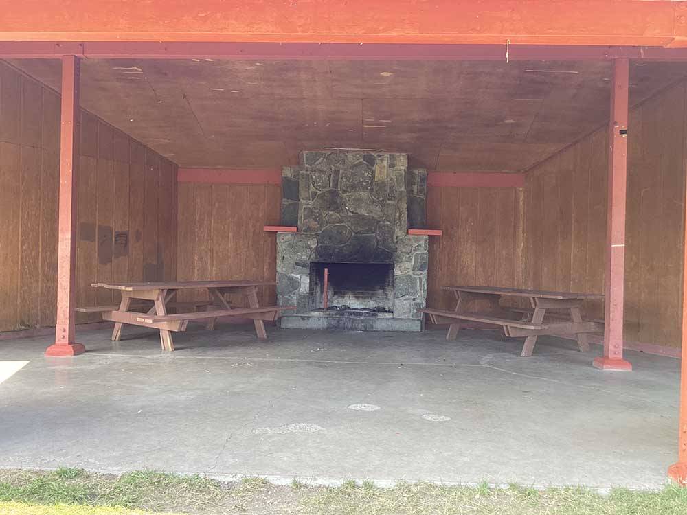 Canopy covers wooden picnic chairs and fireplace at CHEWING BLACK BONES CAMPGROUND