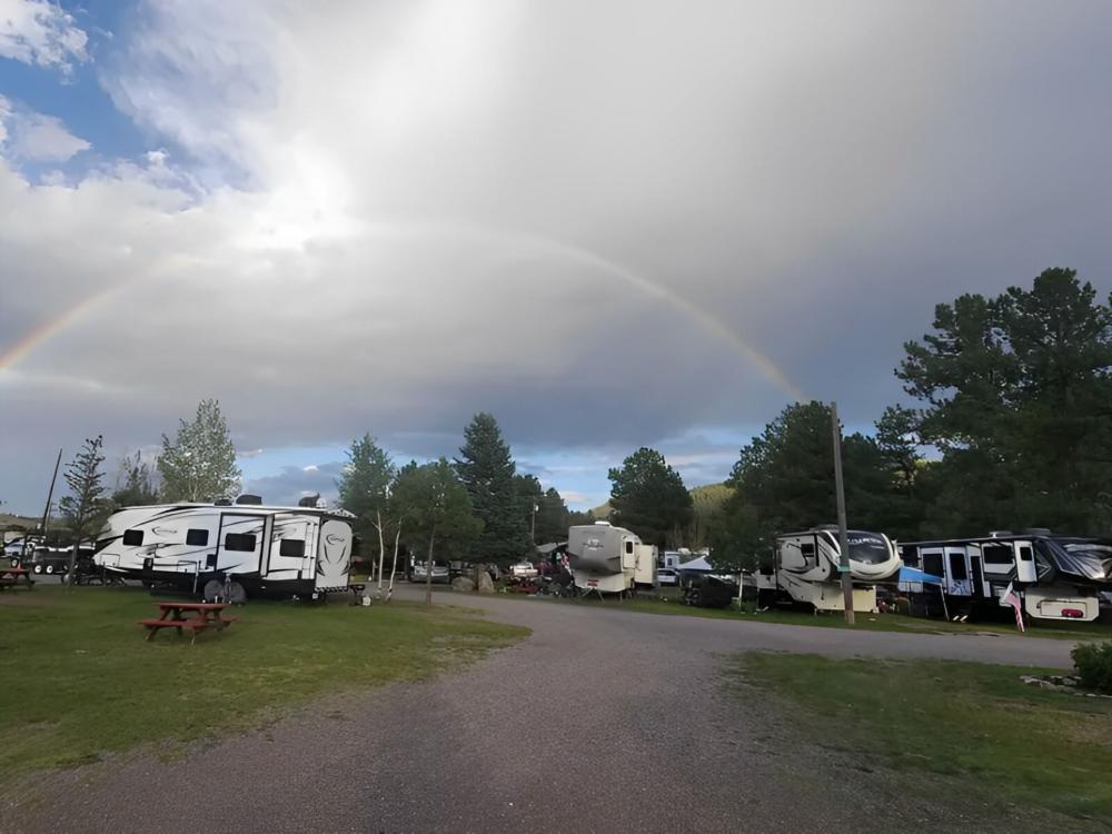 RVs parked in sites and a rainbow in the sky