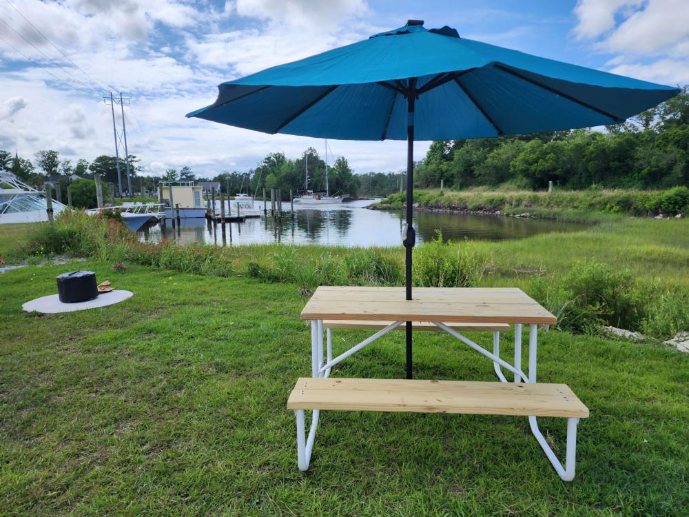 Picic table and firepit at grassy Rv site by the water