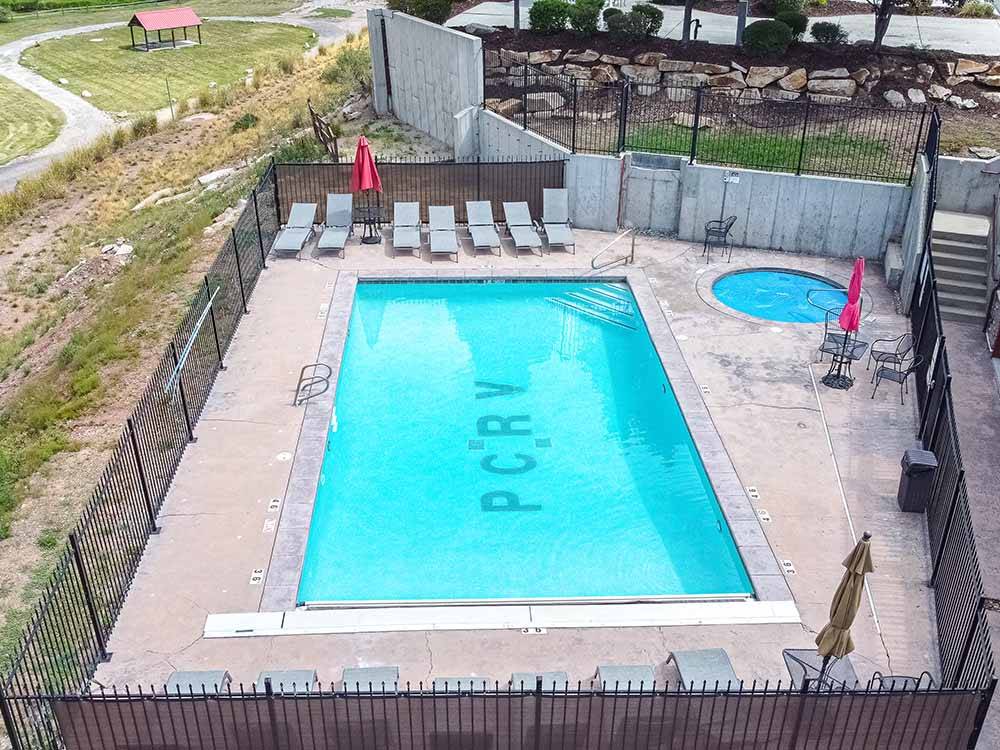 Pool and hot tub with lounge chairs at PARK CITY RV RESORT