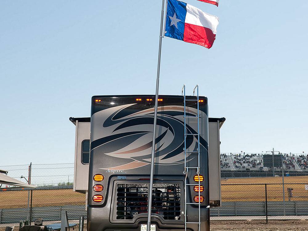 The back of an RV with a flag flying at COTA CAMPING-PREMIUM RV PARK