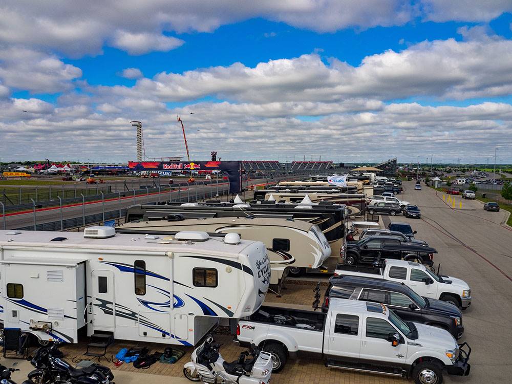 A row of trailers parked next to the race track at COTA CAMPING-PREMIUM RV PARK