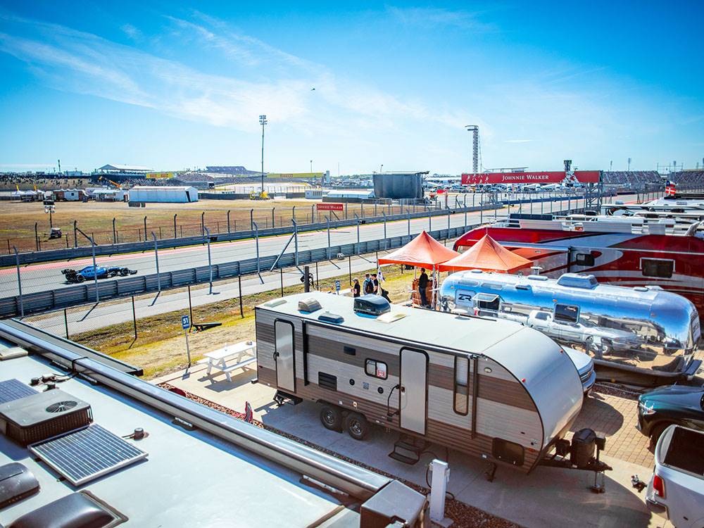 Another view of trailers parked by the race track at COTA CAMPING-PREMIUM RV PARK