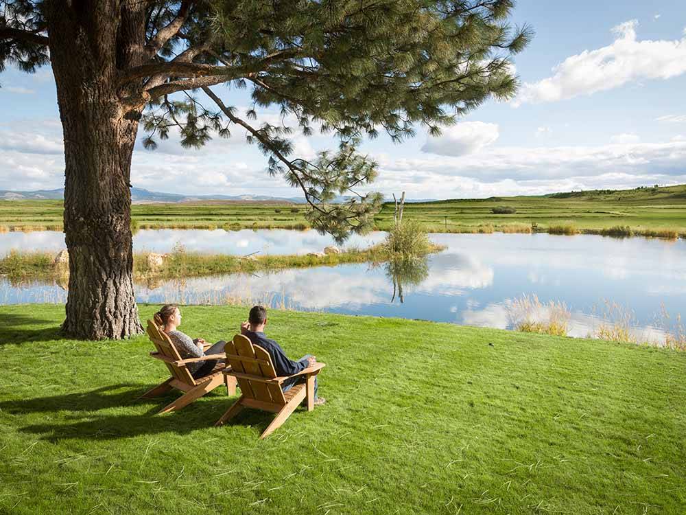 A couple enjoying the view by the water at THE RETREAT, LINKS & SPA AT SILVIES VALLEY RANCH