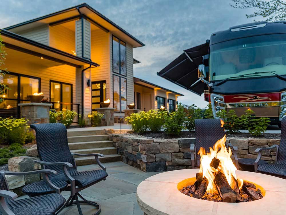 A fire pit burning with a motorhome in the back at MOTORCOACH RESORT LAKE ERIE SHORES