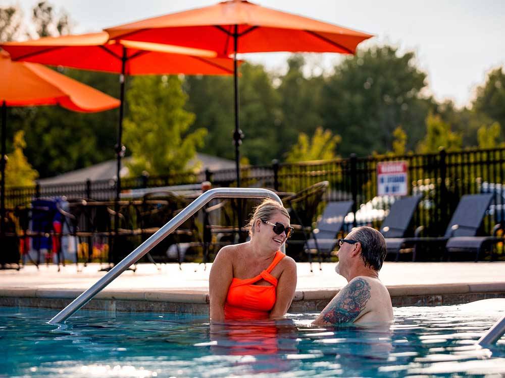 A couple lounging at the pool at MOTORCOACH RESORT LAKE ERIE SHORES
