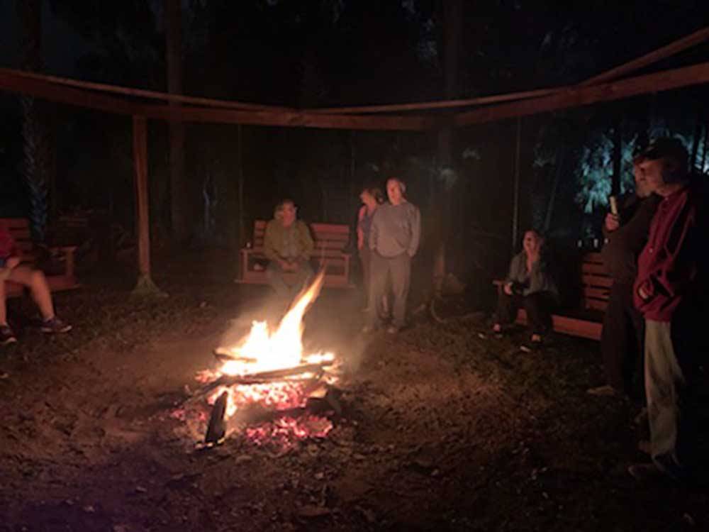 Group of people gathered around a fire pit at HAINES CREEK RV PARK