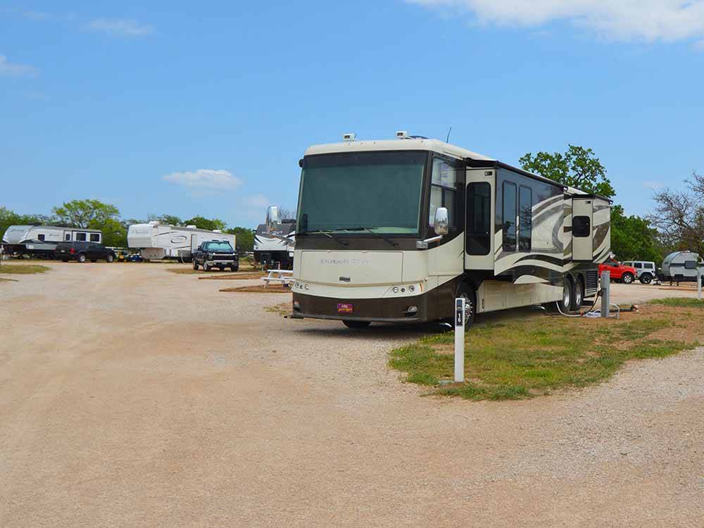 A row of gravel RV sites at FREEDOM LIVES RANCH RV RESORT