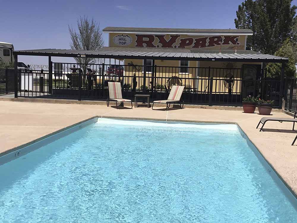 Lounge chairs by the swimming pool at HILLTOP RV PARK