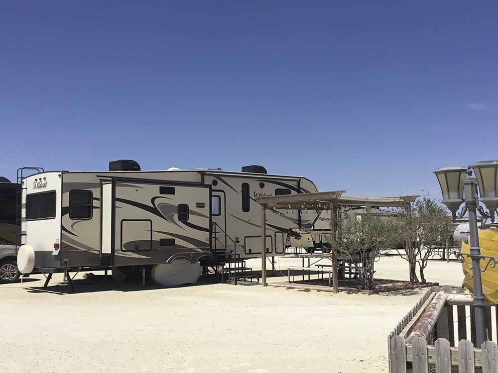 A gravel campsite with covered seating at HILLTOP RV PARK