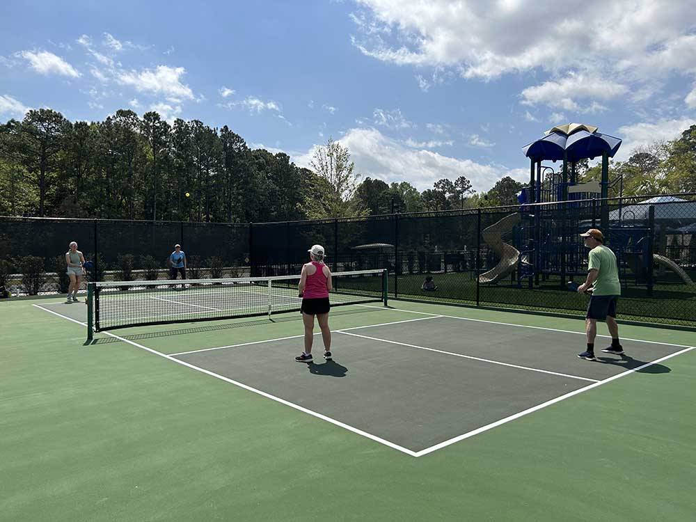Two couples playing pickleball at HILTON HEAD NATIONAL RV RESORT