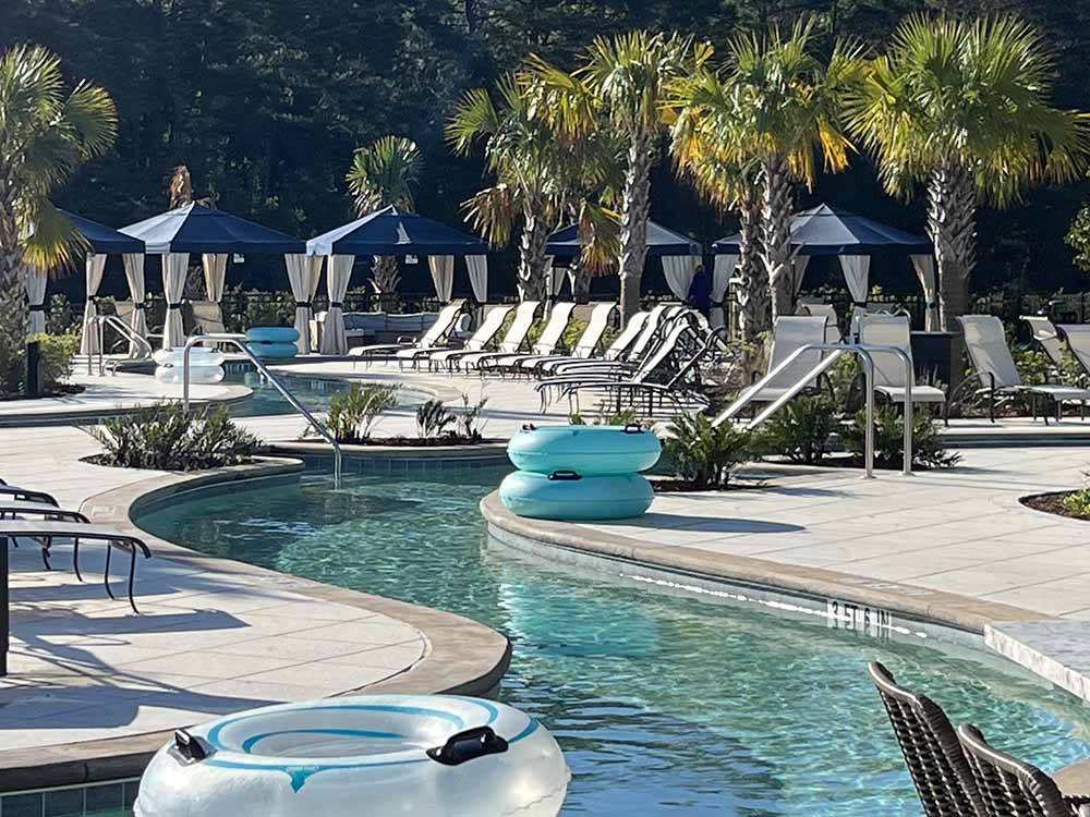 A view of the lazy river with inner tubes on the side of it at HILTON HEAD NATIONAL RV RESORT
