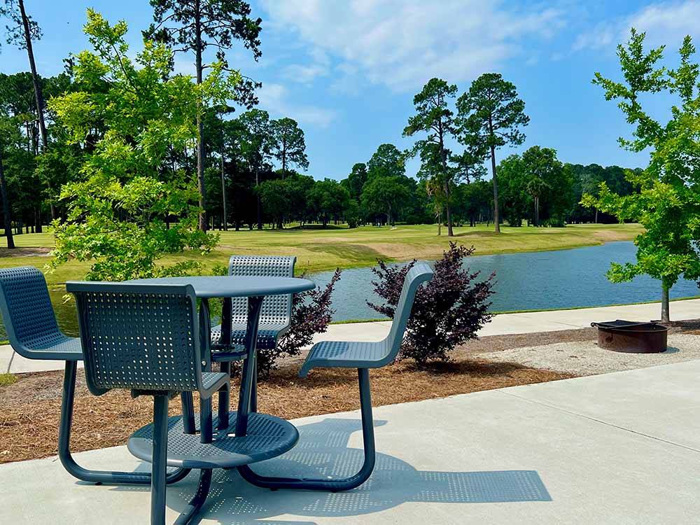 Table and fire pit next to the pond at HILTON HEAD NATIONAL RV RESORT