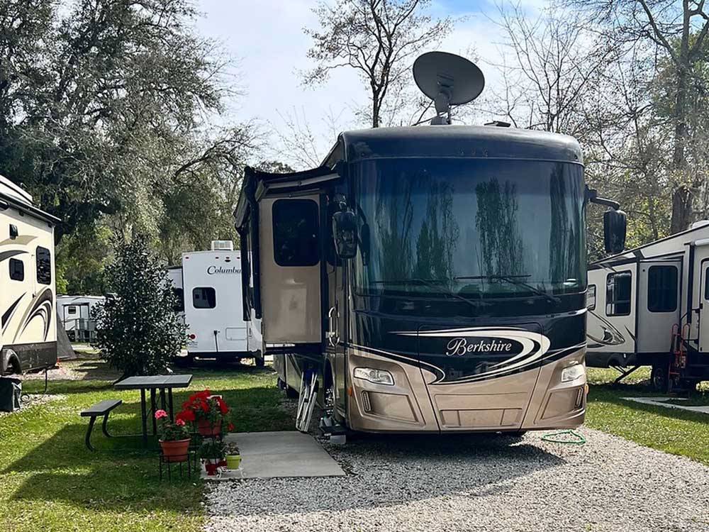 A motorhome parked in a gravel site at SUNNY OAKS RV PARK